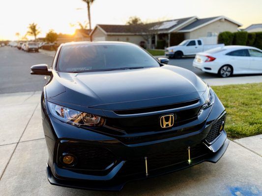 A black honda civic is parked on the side of the road