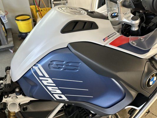 A blue and white bmw motorcycle is parked in a garage