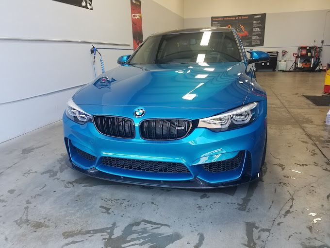 a blue bmw m3 is parked in a garage .