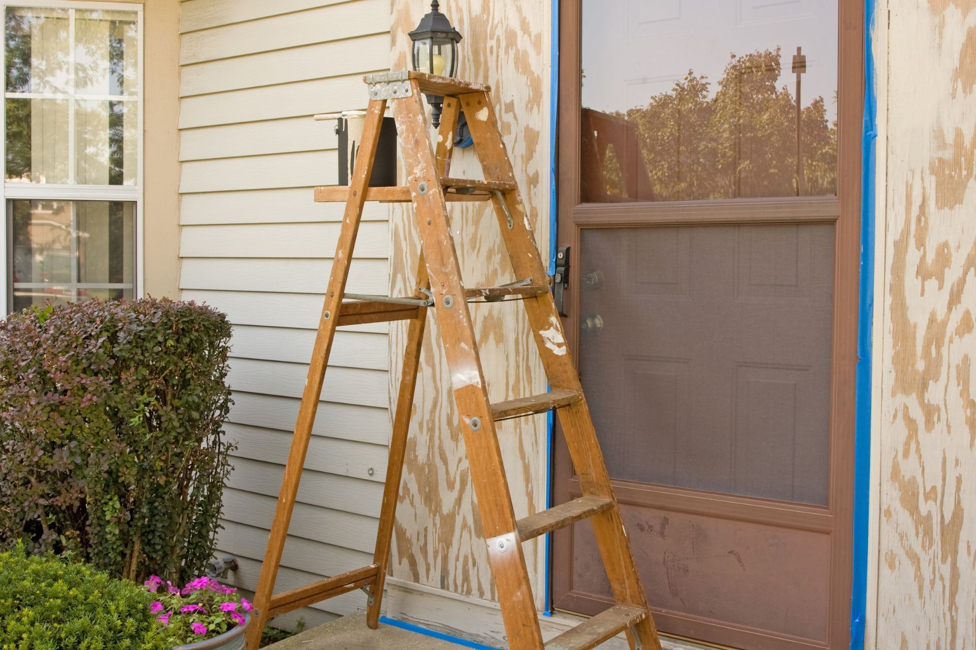 Ladder leaning against a house, next to the front door. Exterior painting in progress. Home Repair Mt Juliet