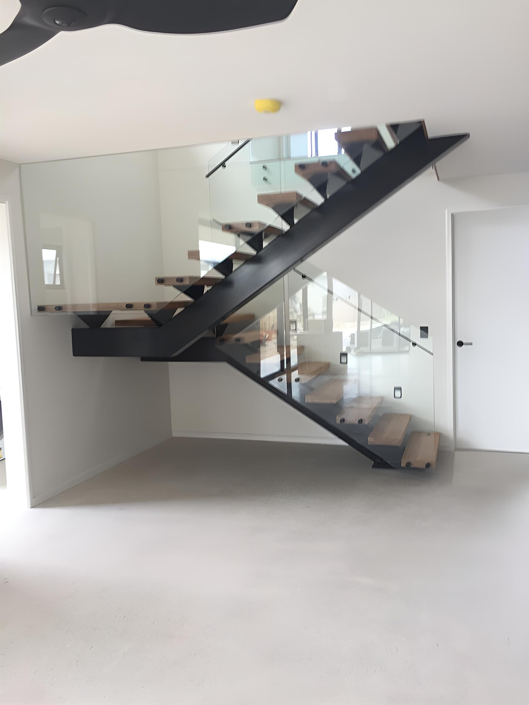 A Staircase With a Glass Railing in an Empty Room — Simmweld Metal Fabrication and Welding In South Murwillumbah, NSW