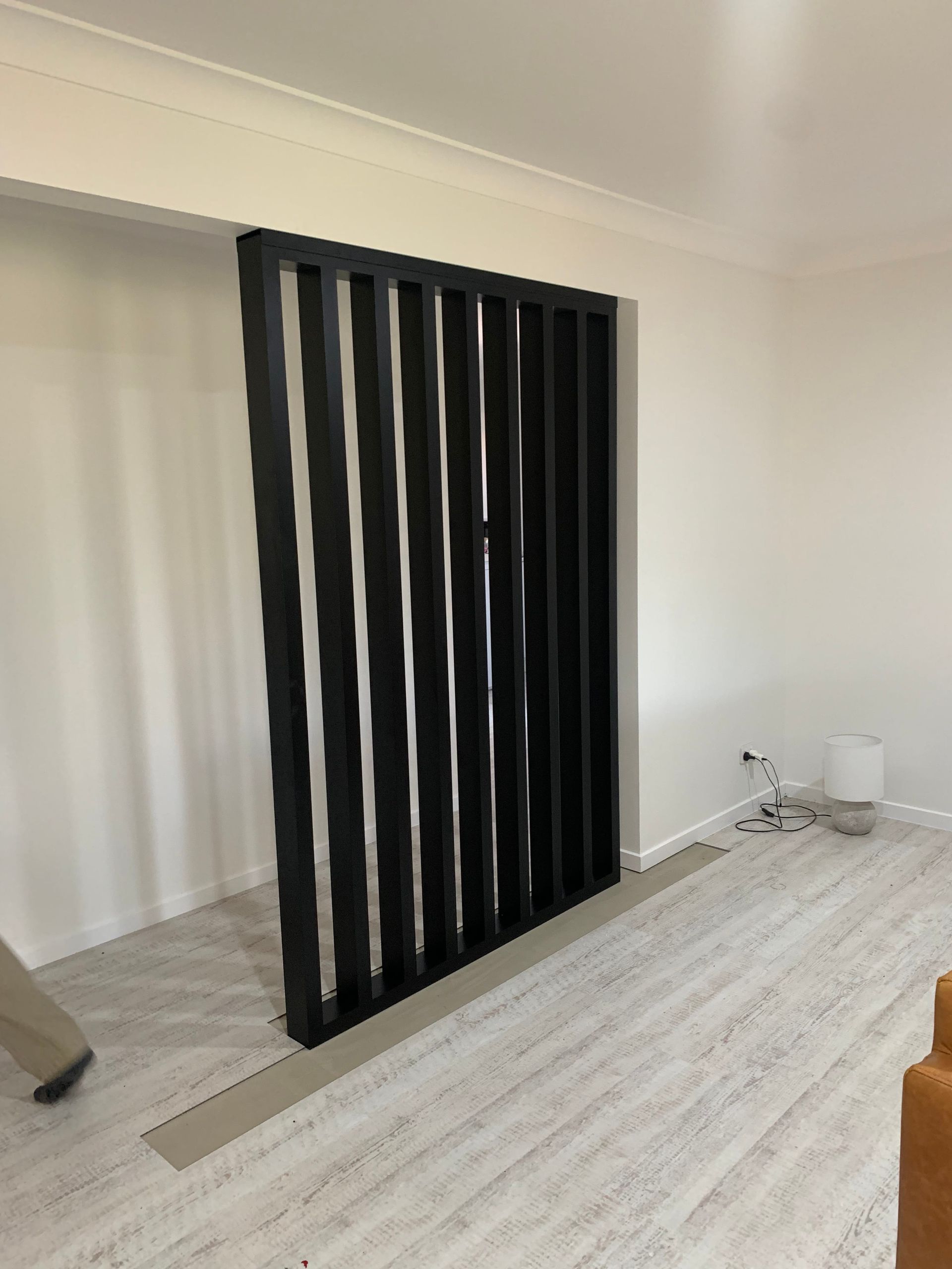 A living room with a black divider in the middle of it — Simmweld Metal Fabrication and Welding In Banora Point, NSW