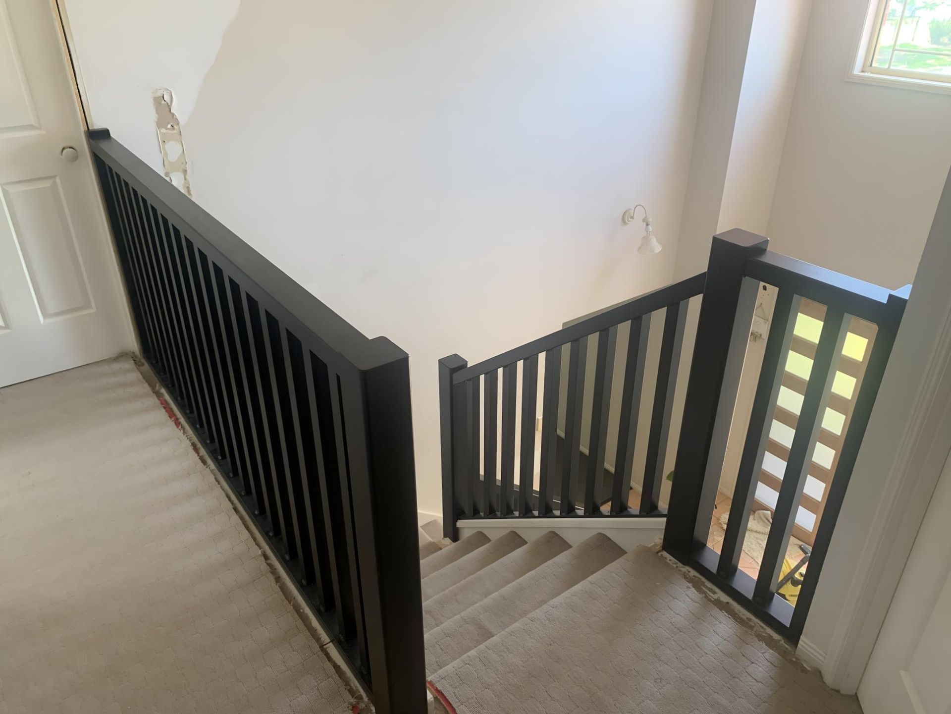 A Staircase With a Black Railing and a Window in a House — Simmweld Metal Fabrication and Welding In South Murwillumbah, NSW