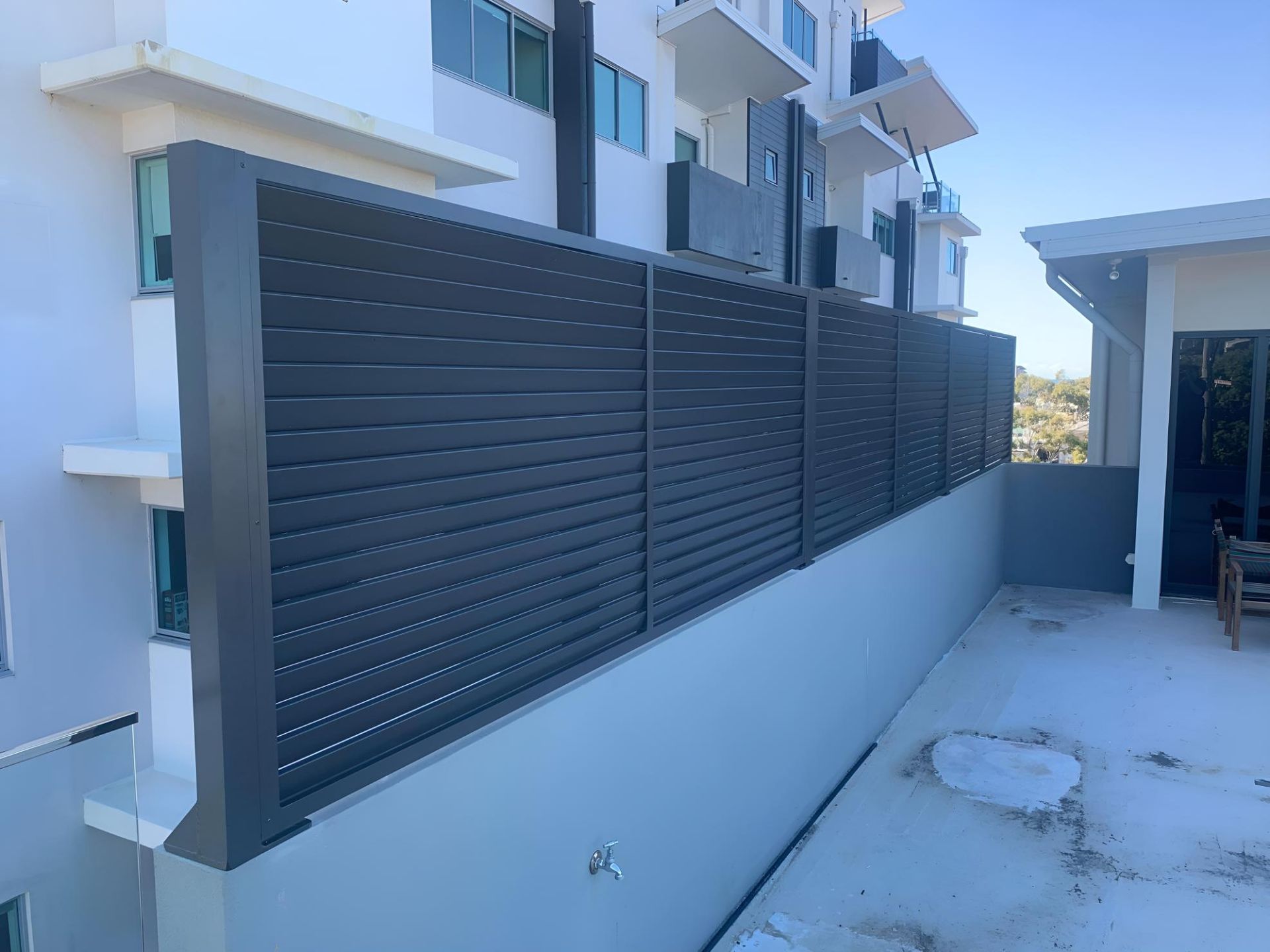 A Fence is Being Built on the Side of a Building — Simmweld Metal Fabrication and Welding In South Murwillumbah, NSW