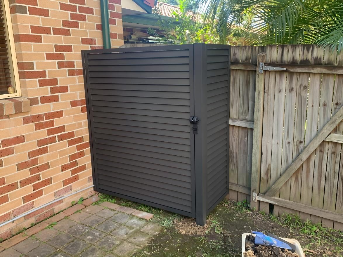 A Black Shed is Sitting on the Side of a Brick Building — Simmweld Metal Fabrication and Welding In South Murwillumbah, NSW
