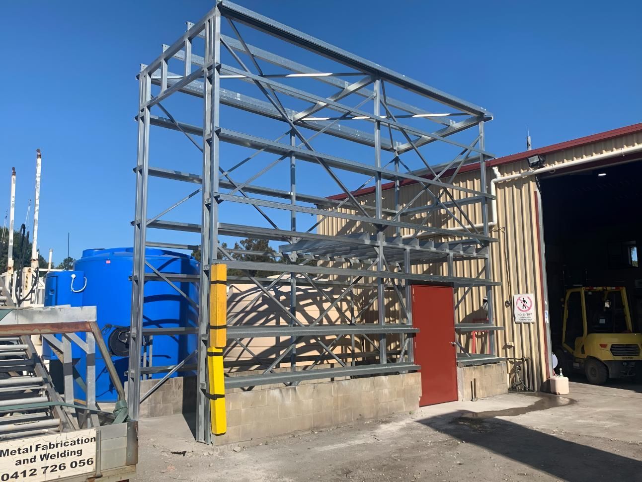 A Large Metal Structure is Being Built in Front of a Building — Simmweld Metal Fabrication and Welding In South Murwillumbah, NSW