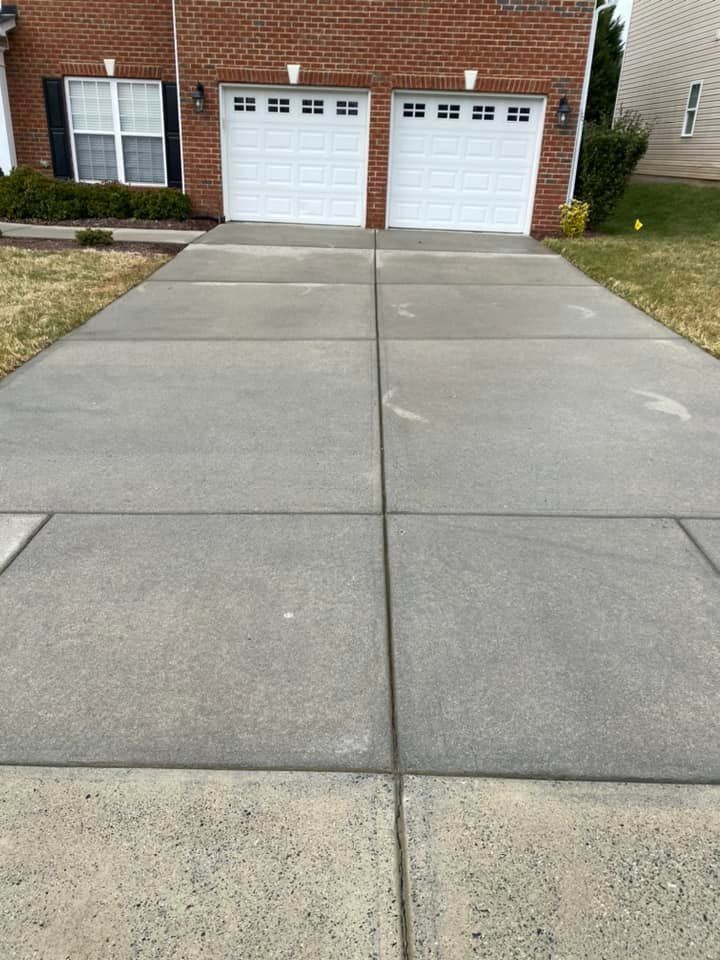 Freshly cleaned driveway after concrete cleaning services using professional power washing equipment