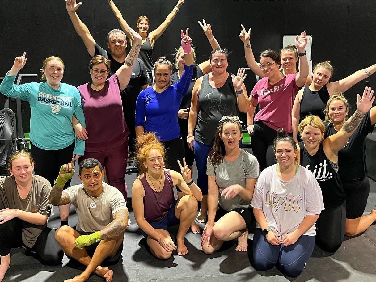 A group of people are posing for a picture in a gym.