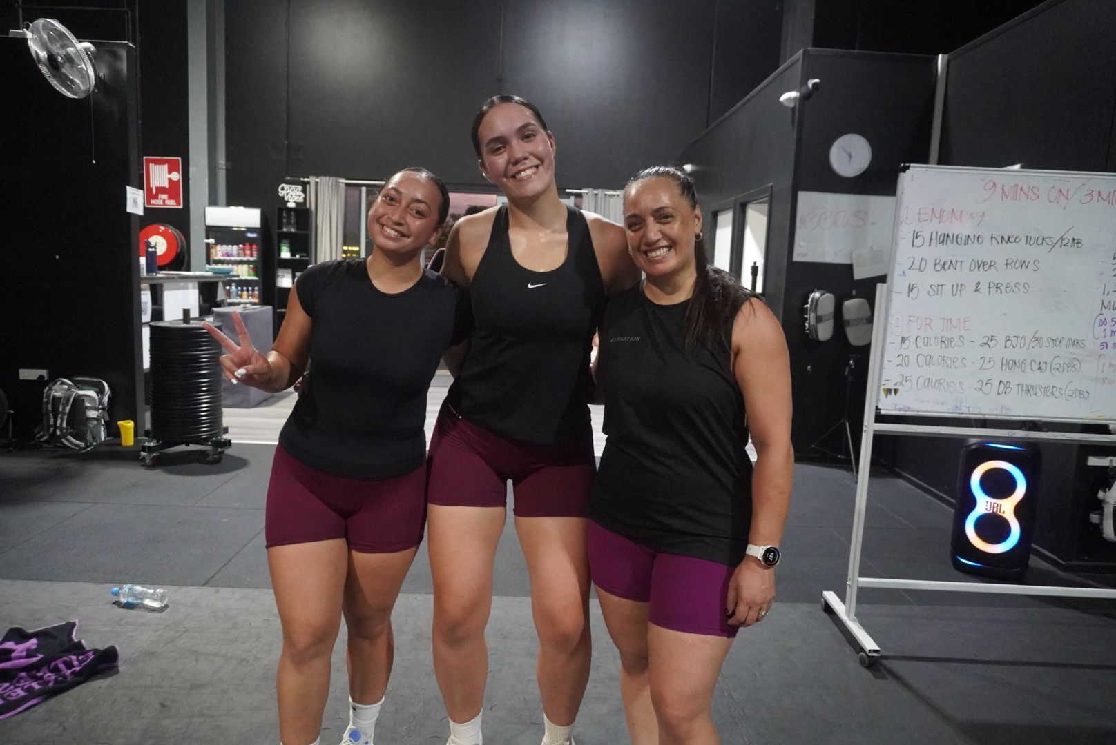 A group of people are posing for a picture in a gym.