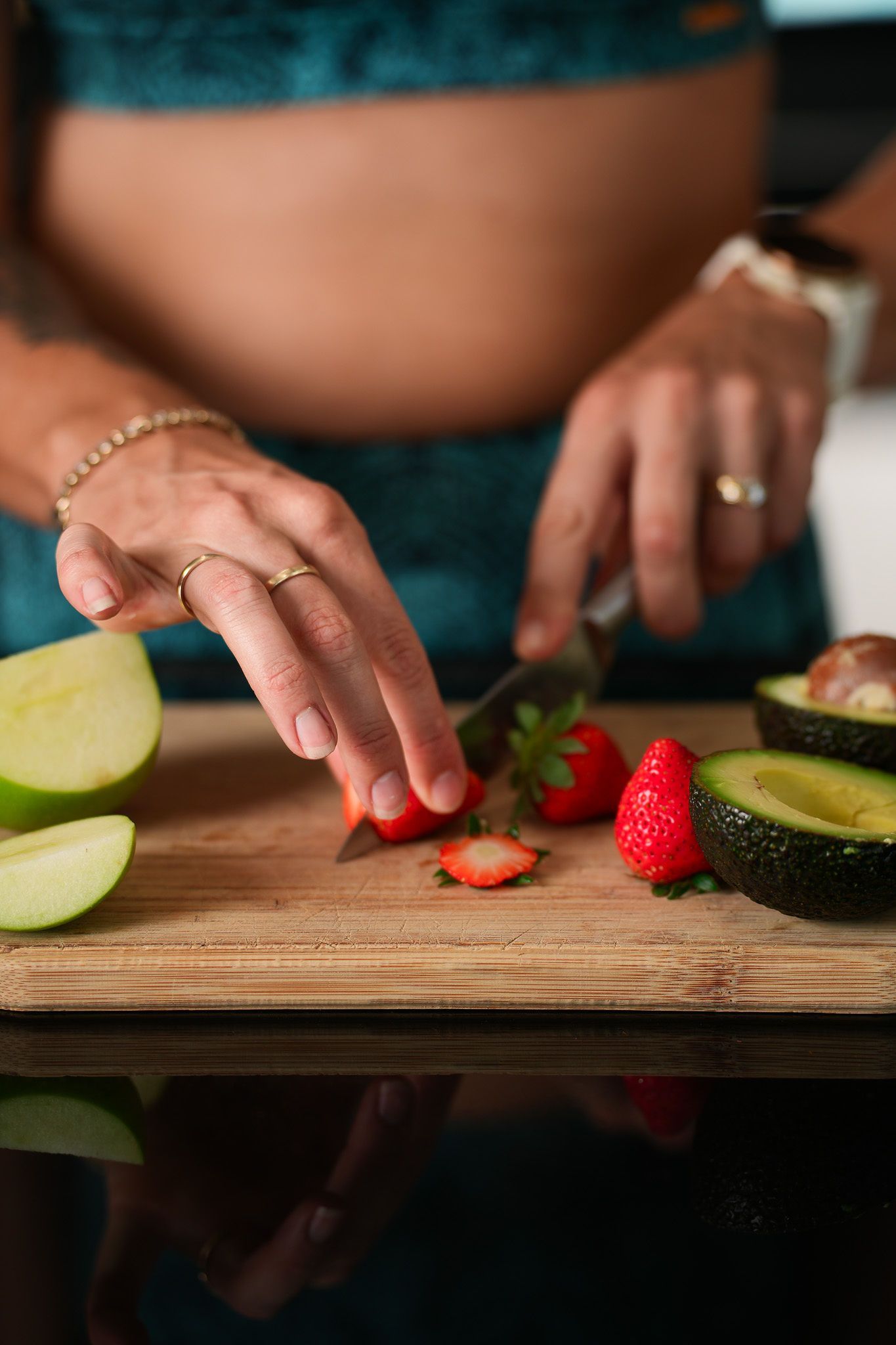 A woman is measuring her waist with a tape measure.