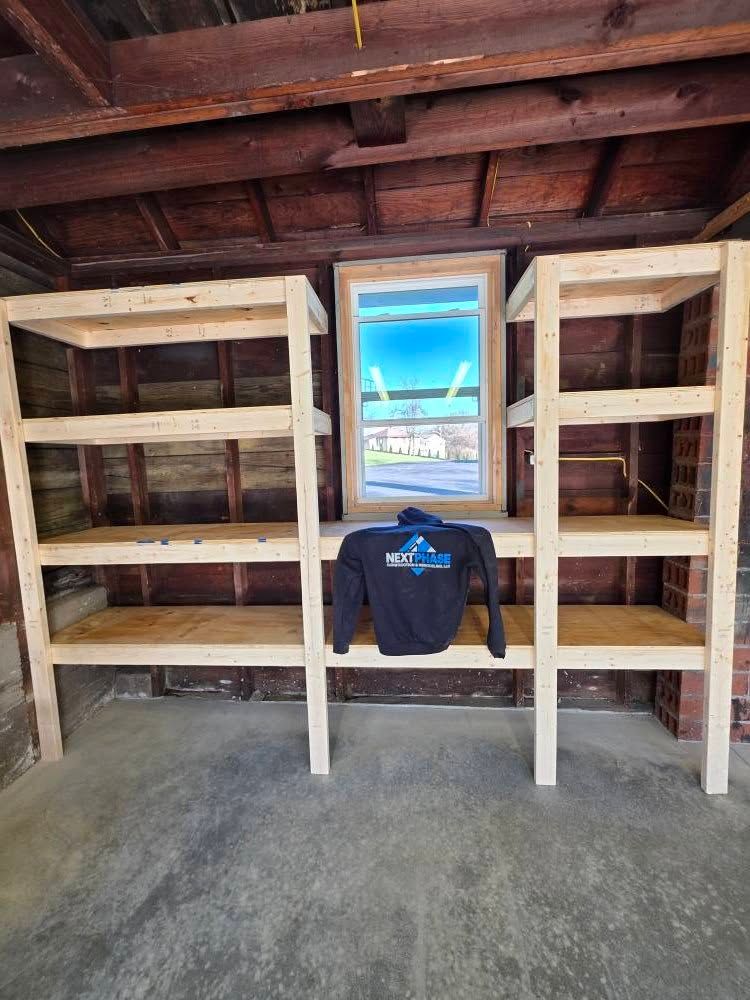 Two wooden shelving units flanking a window, with a sweatshirt resting below the window.