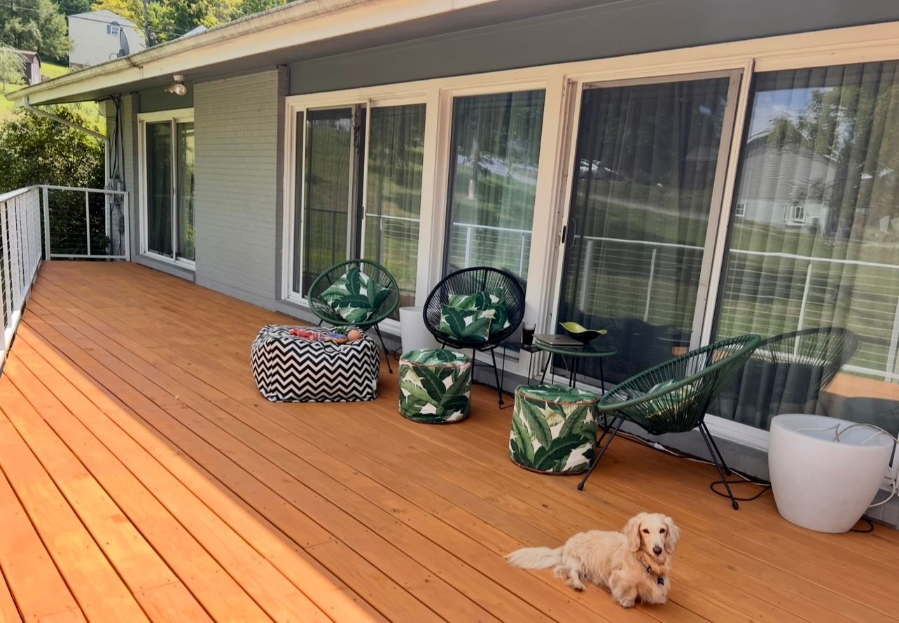 Deck with seating, dachshund dog, and sliding glass doors.