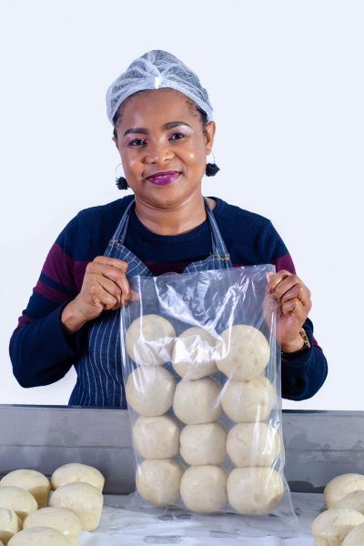 A woman is holding a bag of dough balls.