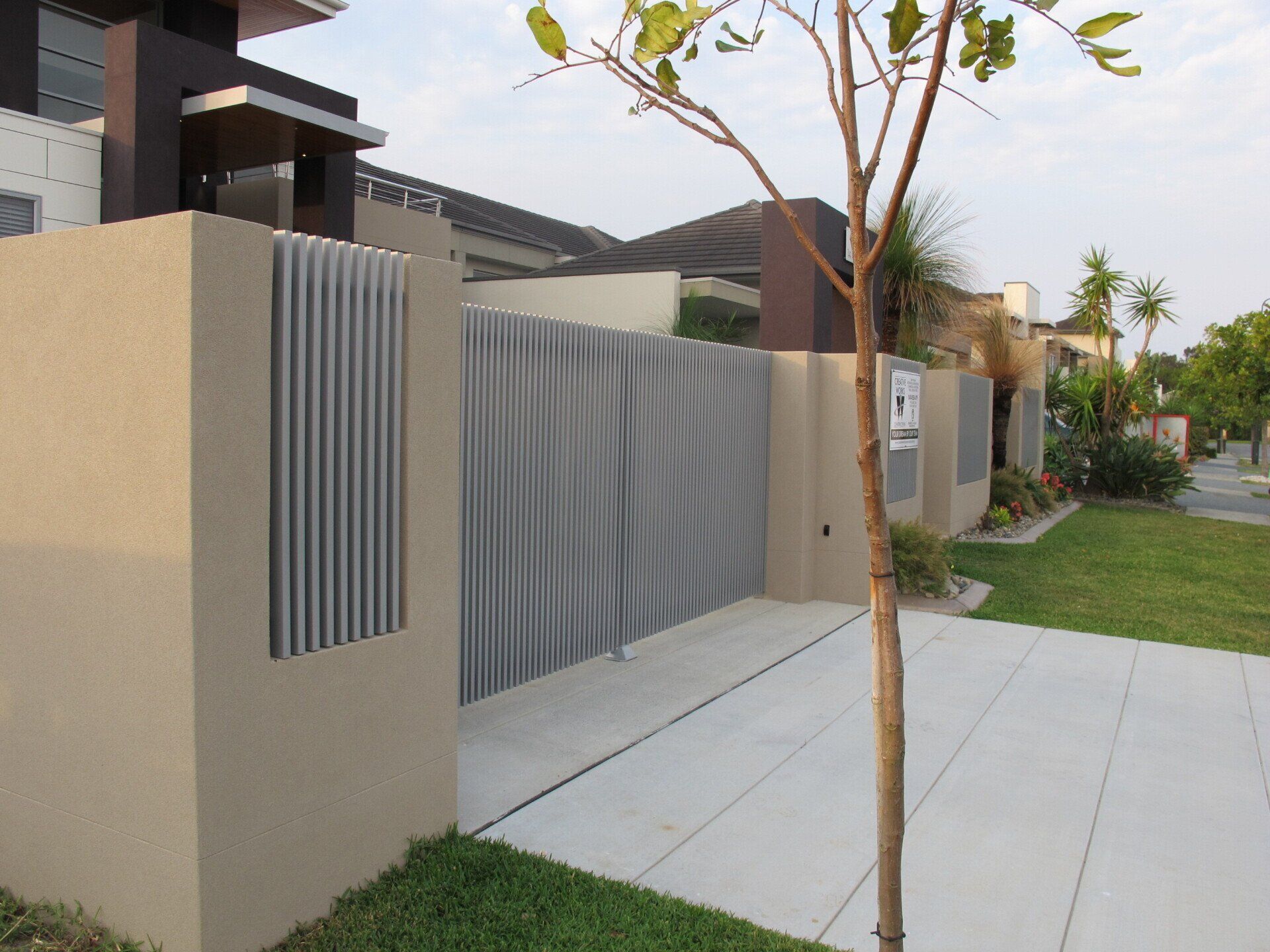 A house with a fence and a tree in front of it