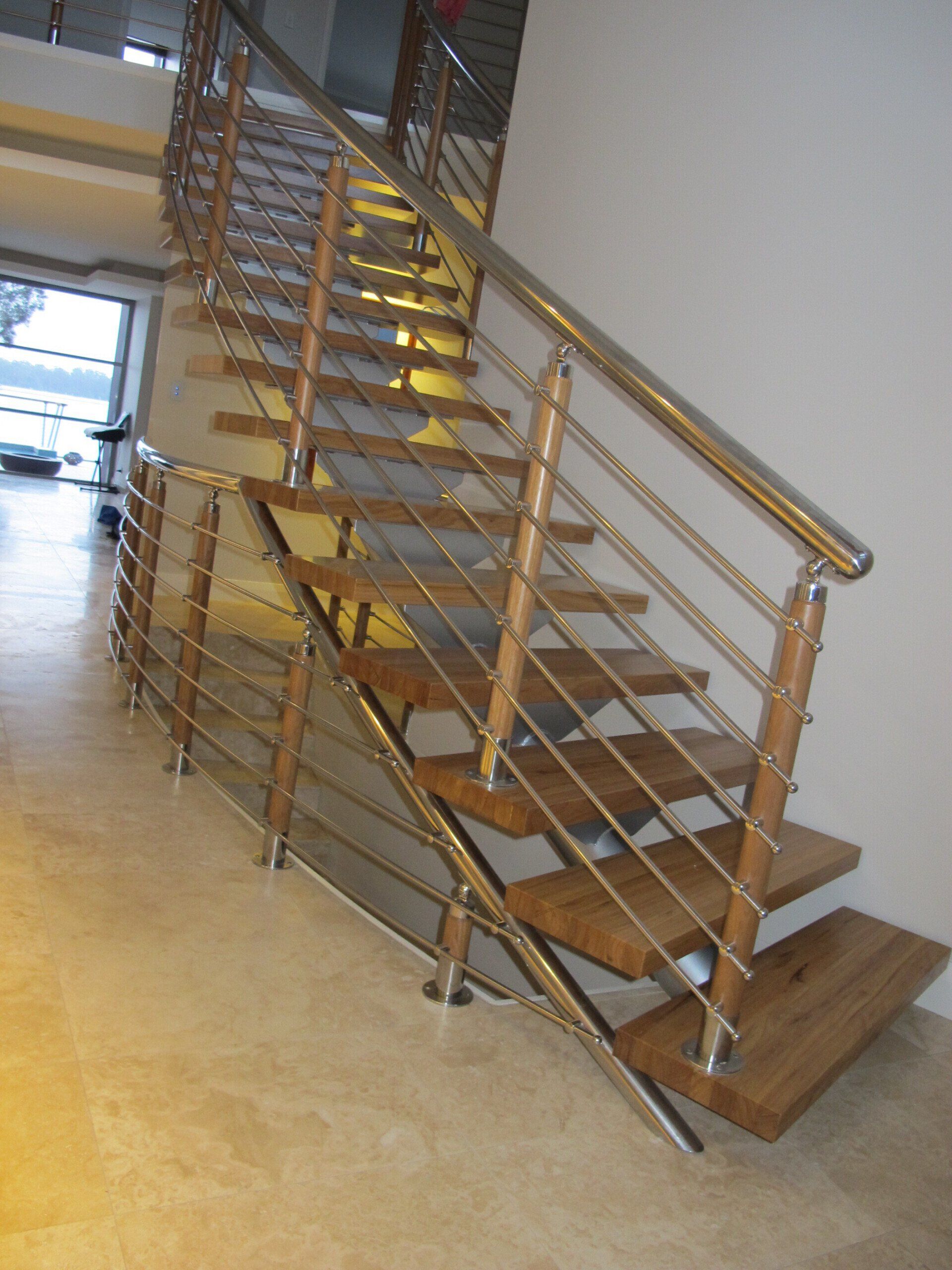 A wooden staircase with a stainless steel railing