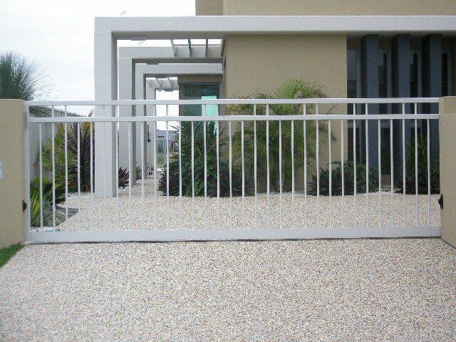 A white gate is open in front of a house