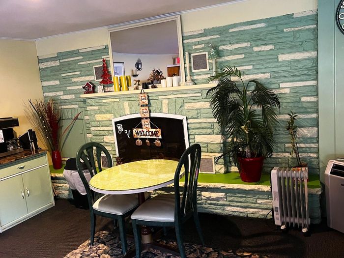 A dining room with a table and chairs and a sign that says welcome