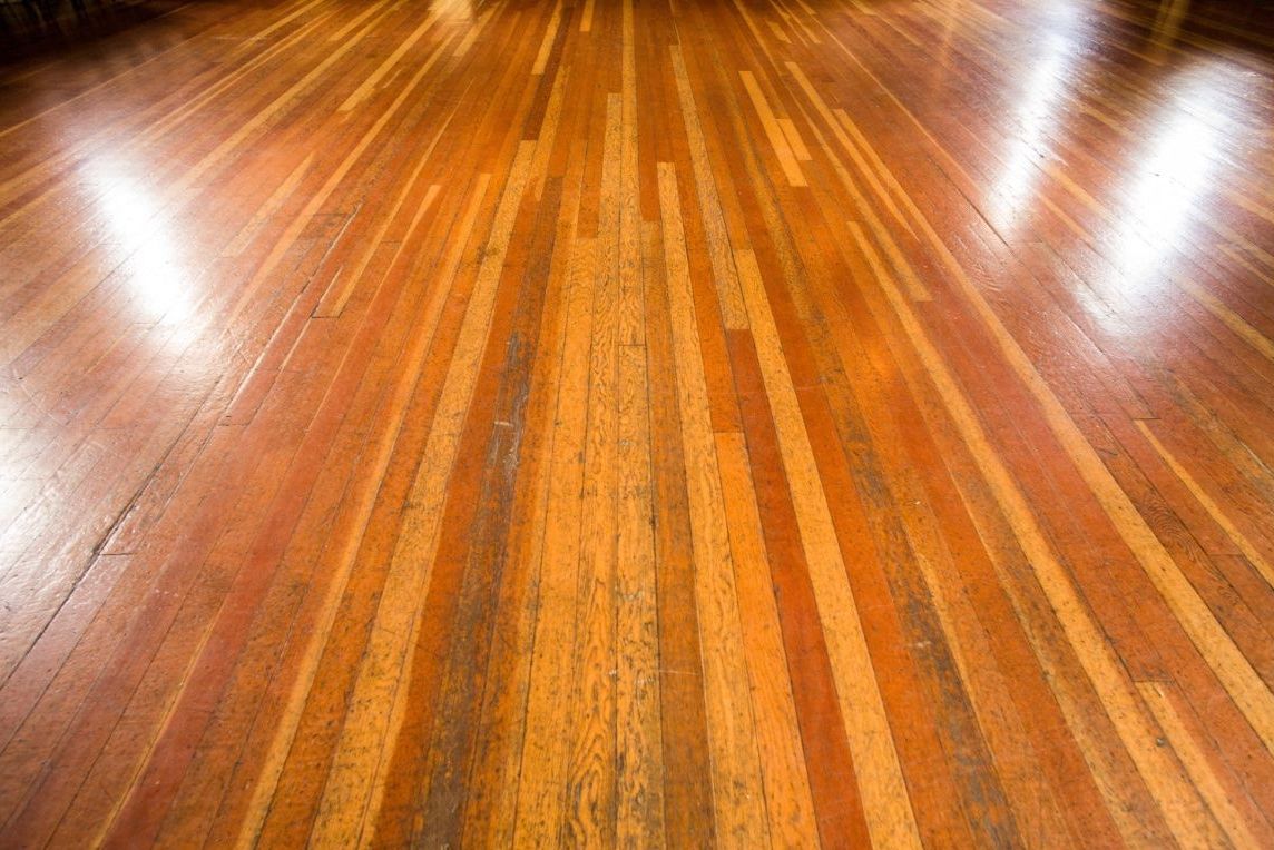 Wood planks that need hardwood floor refinishing services because they are worn and old