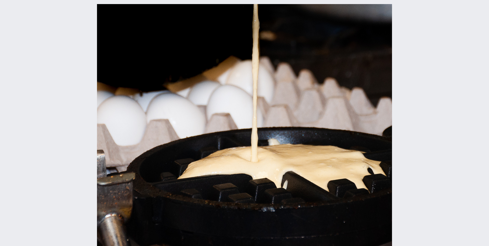 Eggs are being poured into a pan of batter