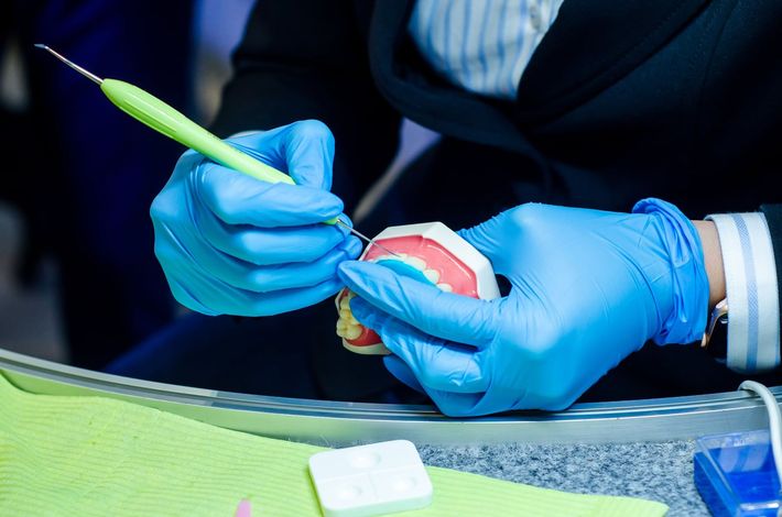 Technician cleaning a dentures at a sterile workstation