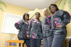 A group of women in scrubs are standing next to each other in a room.