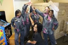 A group of nurses are giving each other a high five in a room.