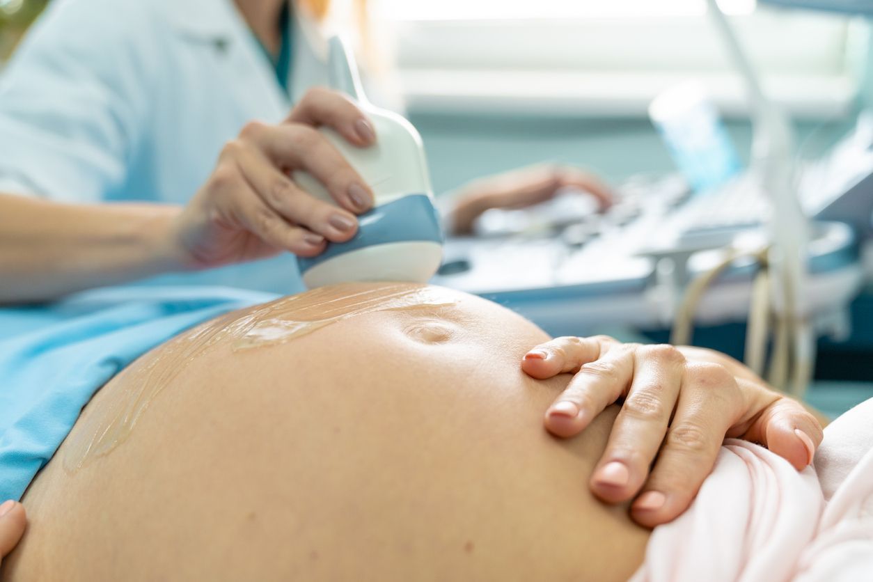 Pregnant patient having a prenatal belly ultrasound exam in a clinic