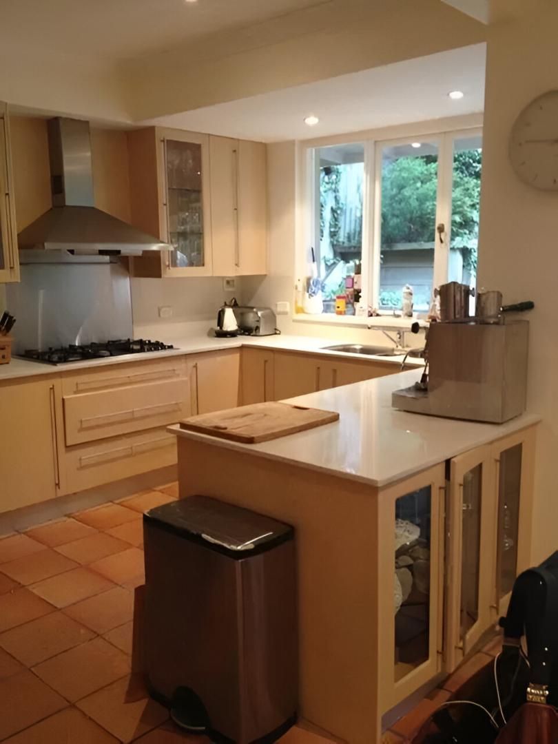 A Kitchen with A Stove Top Oven and A Trash Can — Aqua Blue Plumbing Services in Coffs Harbour, NSW 