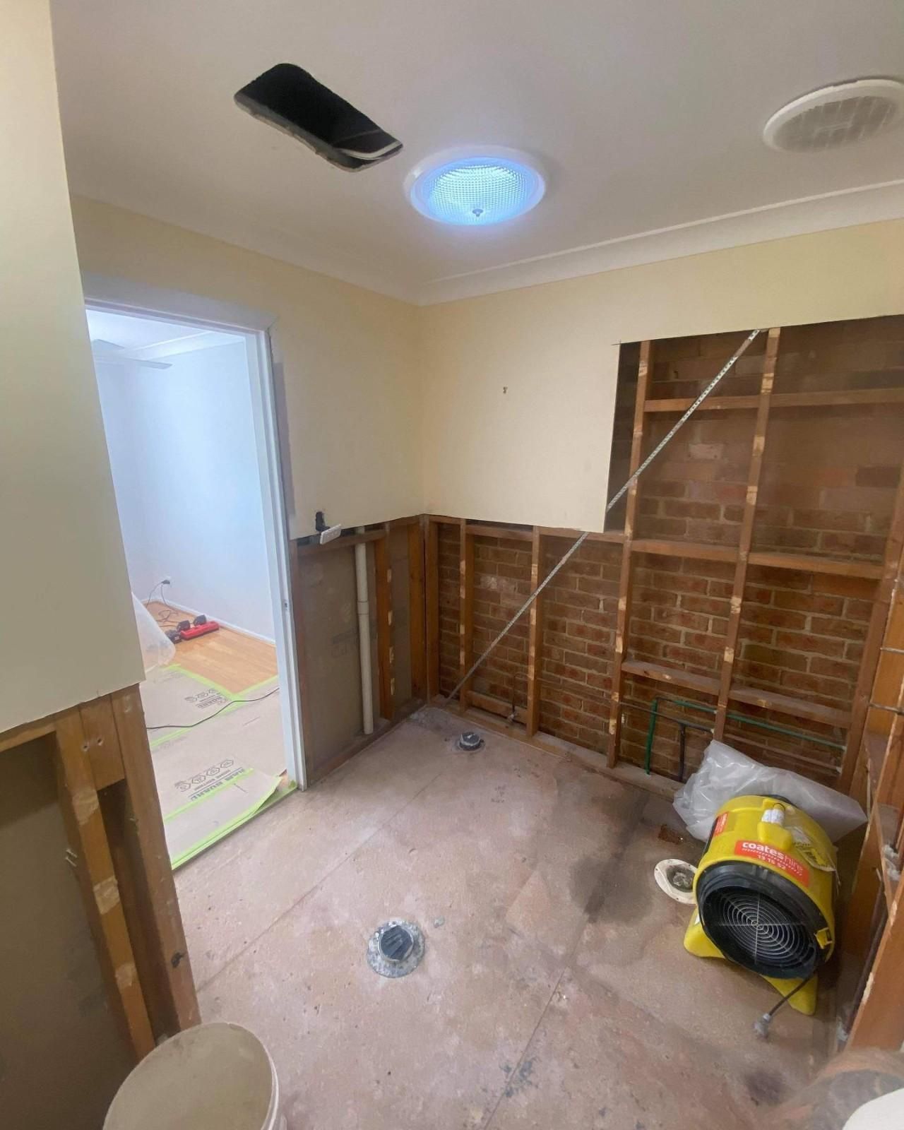 A Bathroom with A Toilet and A Fan in It — Aqua Blue Plumbing Services in Coffs Harbour, NSW