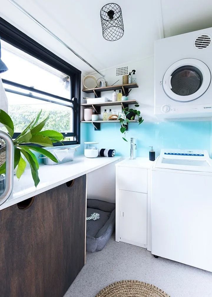 A Laundry Room with A Washer and Dryer, Sink, and Window — Aqua Blue Plumbing Services in Coffs Harbour, NSW 
