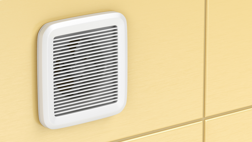 A white air vent is sitting on a yellow wall.