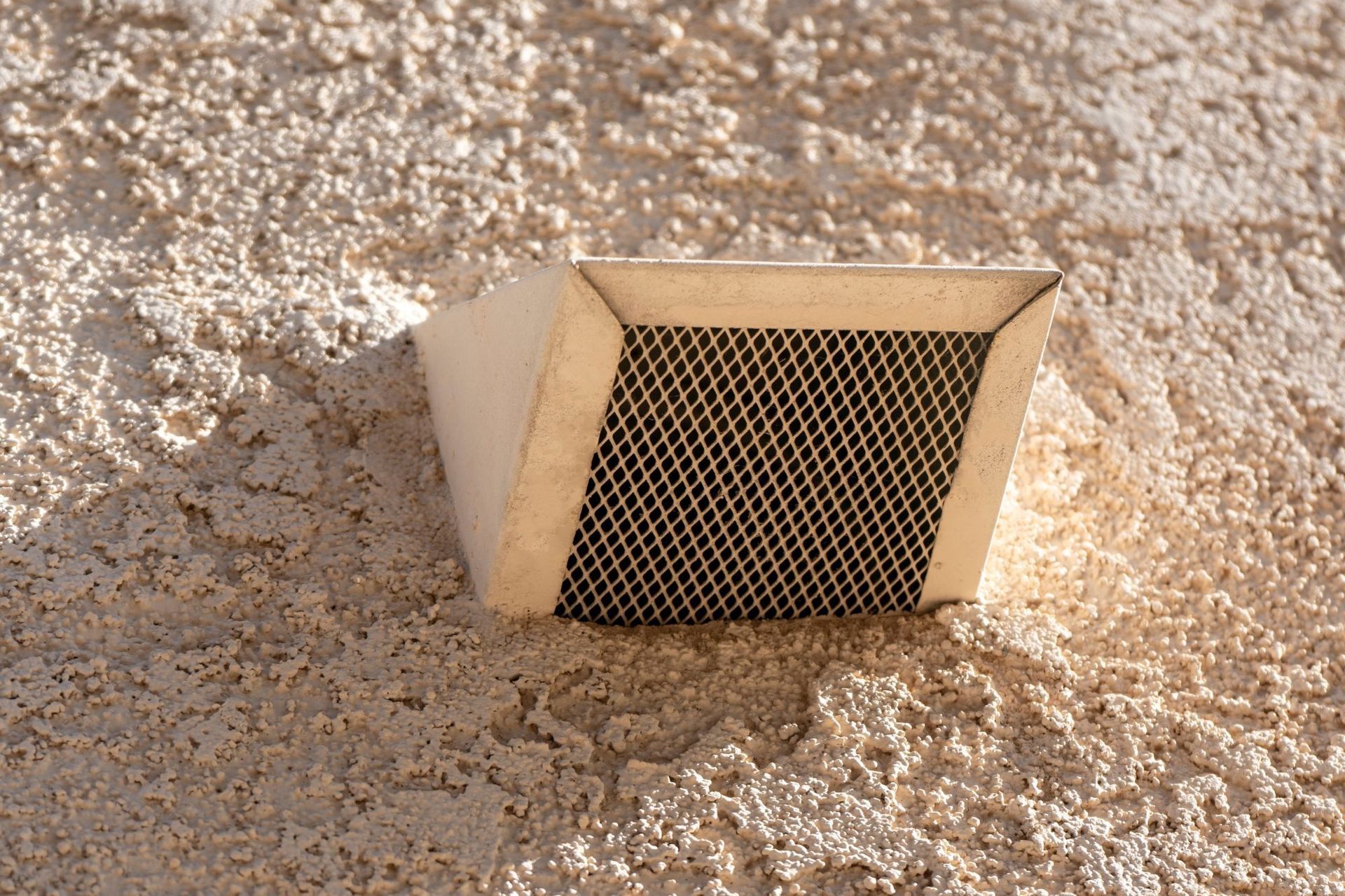 A close up of a drain on a wooden wall.