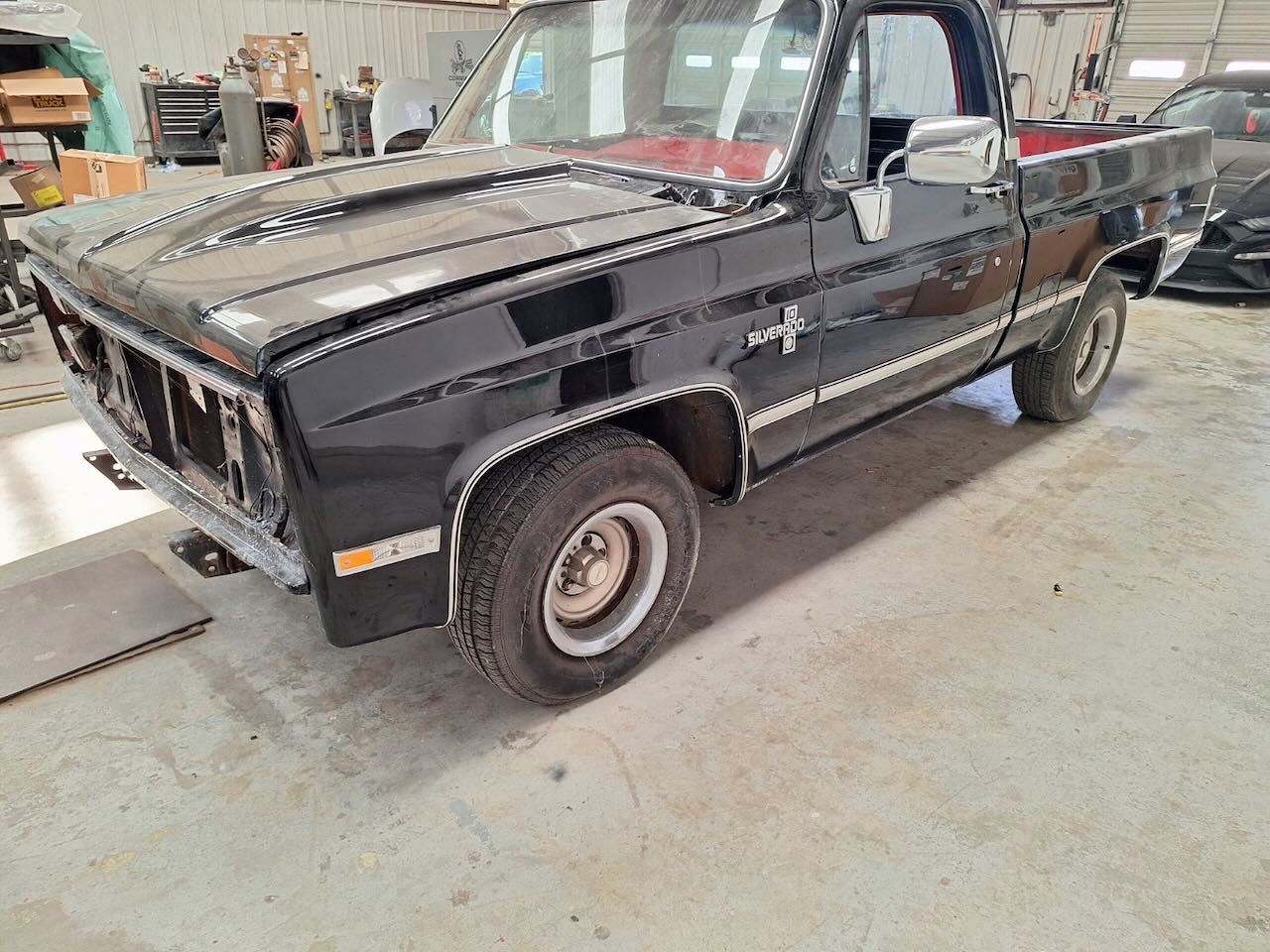 A black truck is parked in a garage.