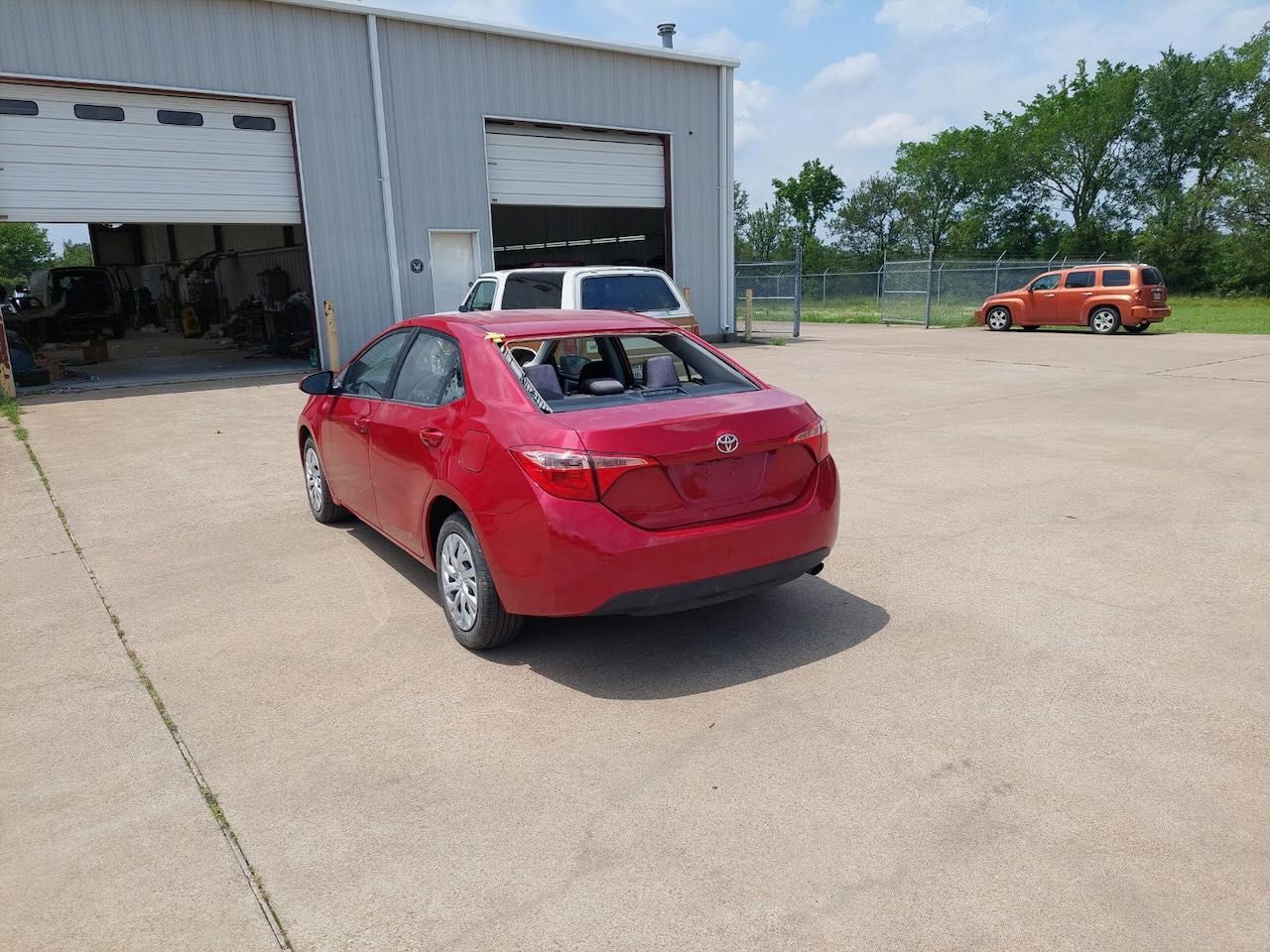 A red car is parked in front of a garage door