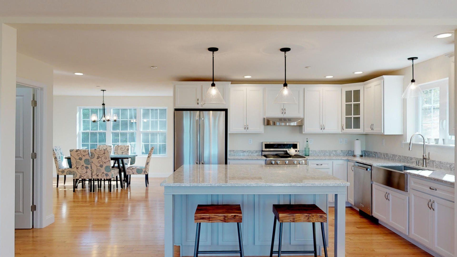 A kitchen with white cabinets and a large island in the middle.
