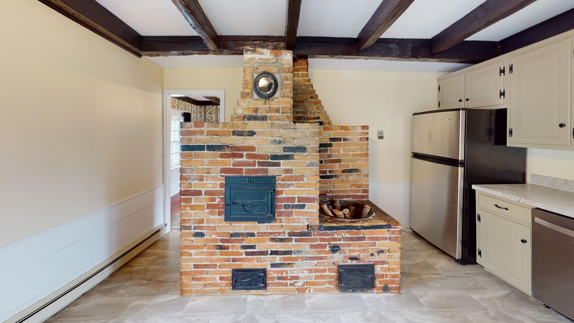 There is a brick fireplace in the middle of the kitchen.