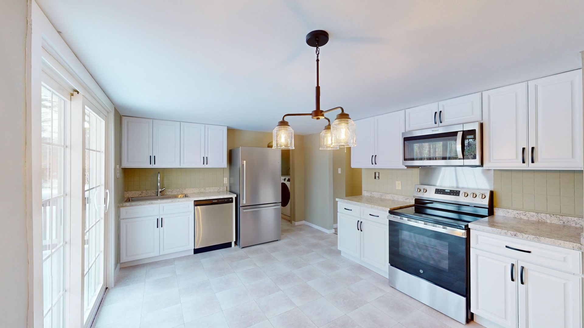 A kitchen with white cabinets and stainless steel appliances.