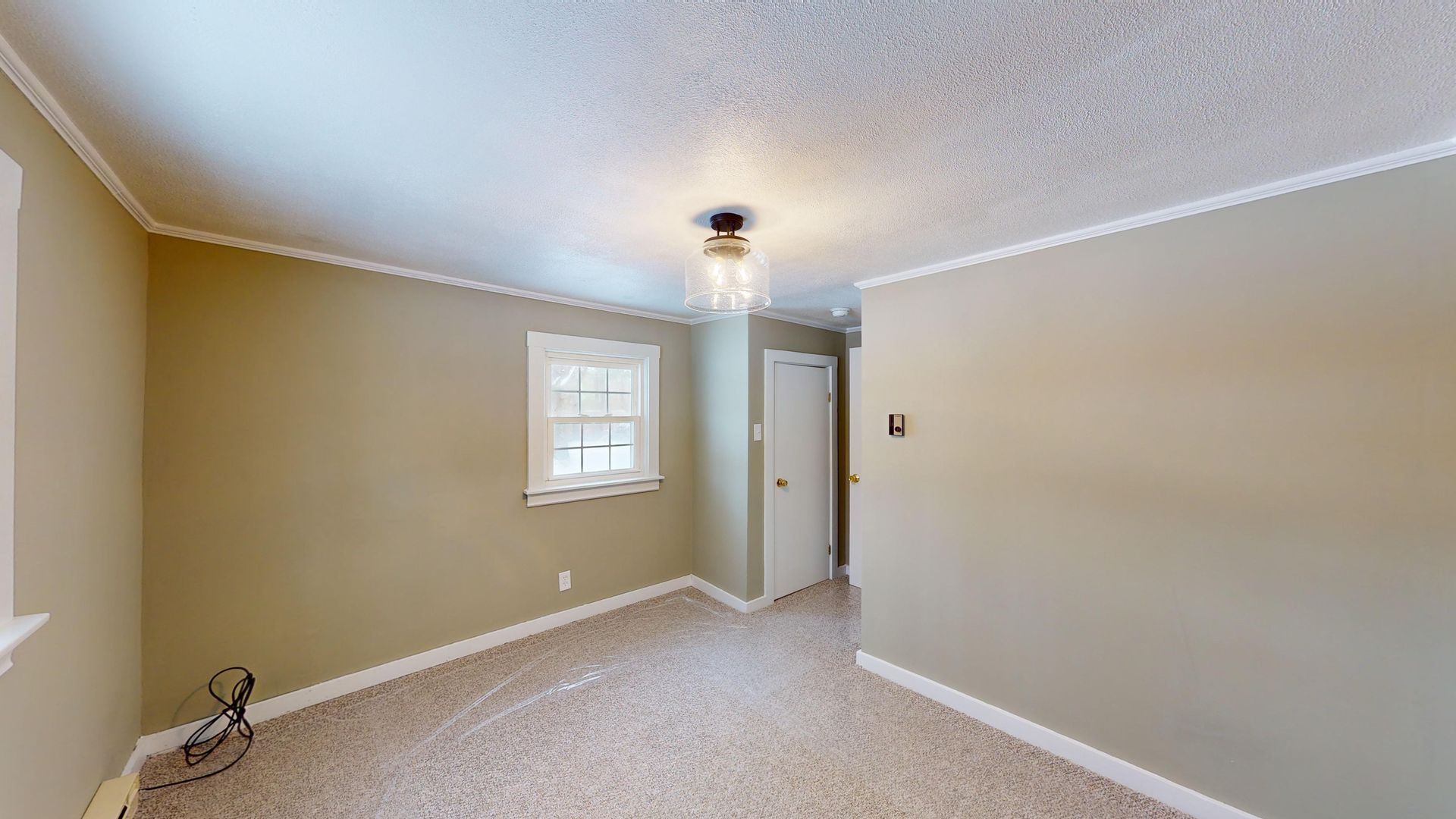 An empty bedroom with a ceiling fan and a window.