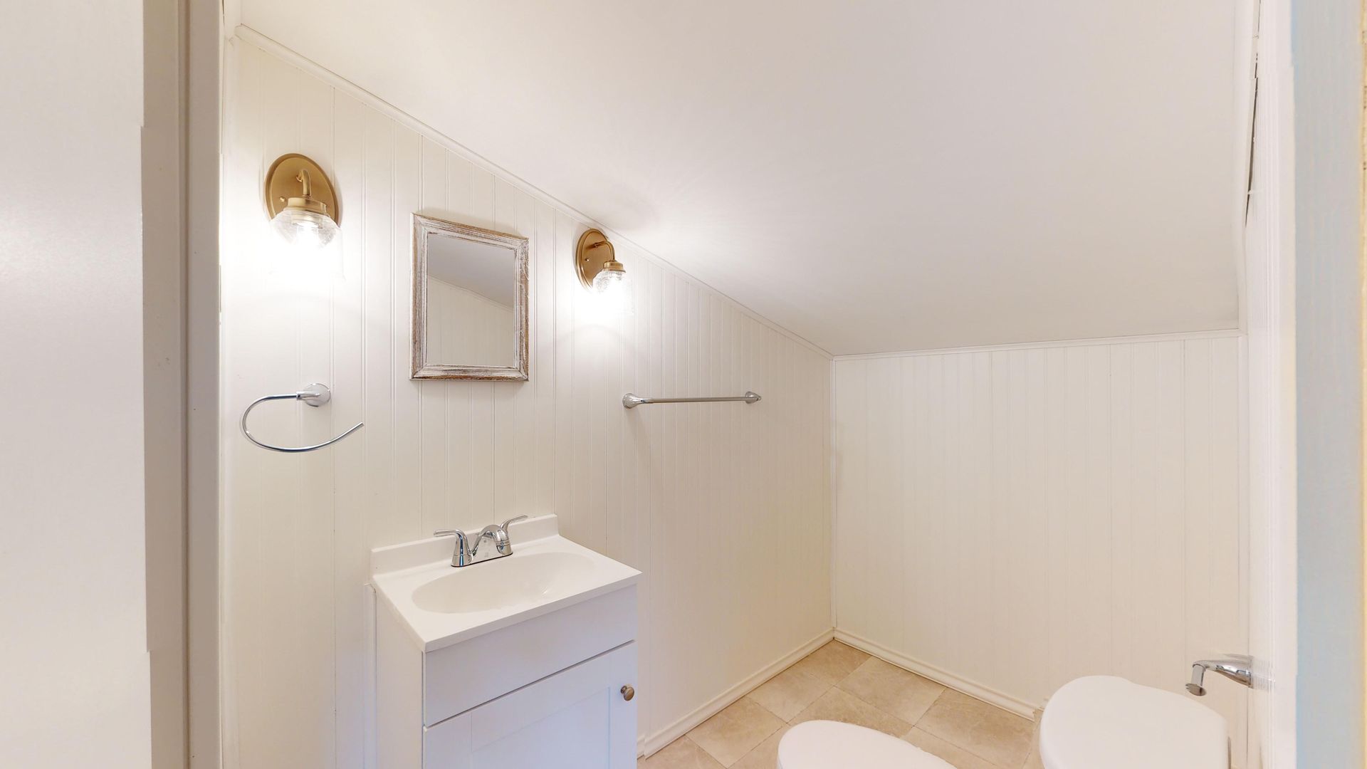 A bathroom with a sink , toilet and mirror.