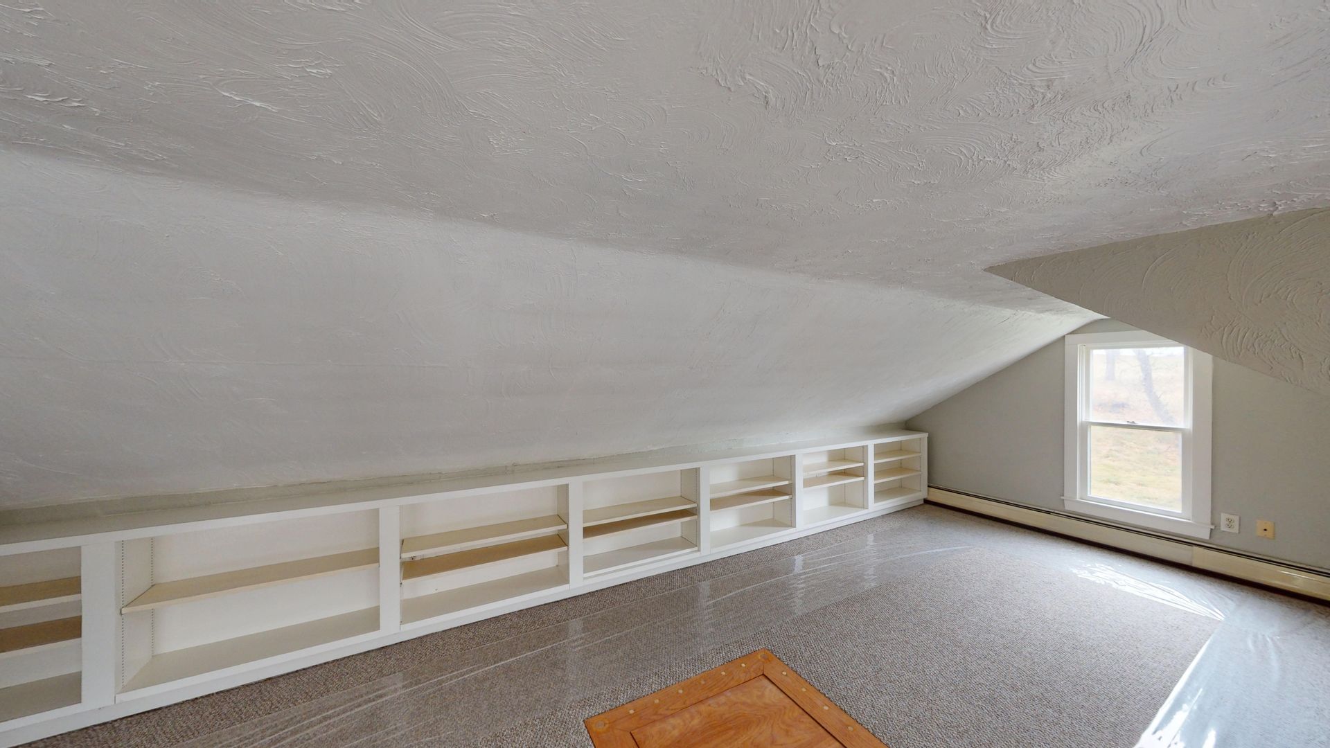 A room with a ceiling that is very high and a lot of shelves.