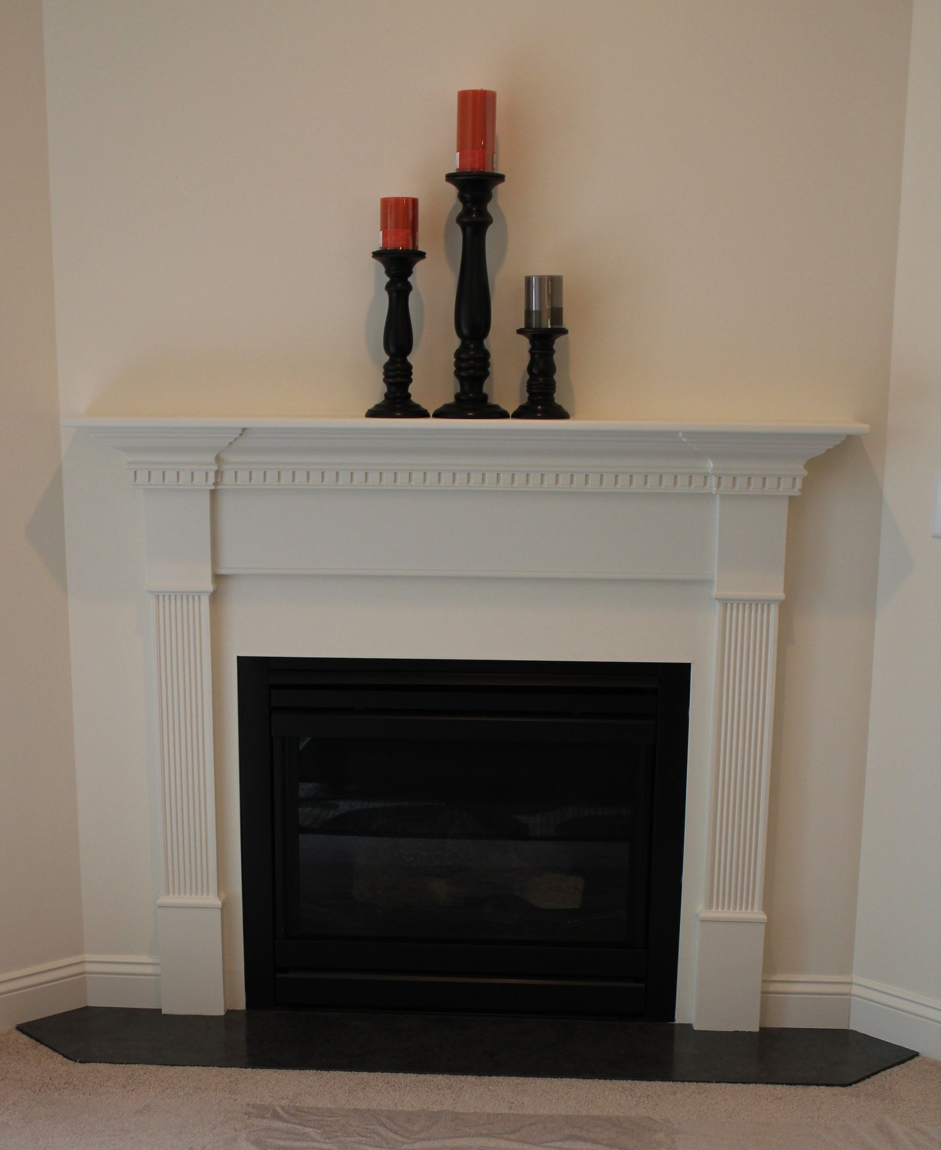 A fireplace with three candles on top of it