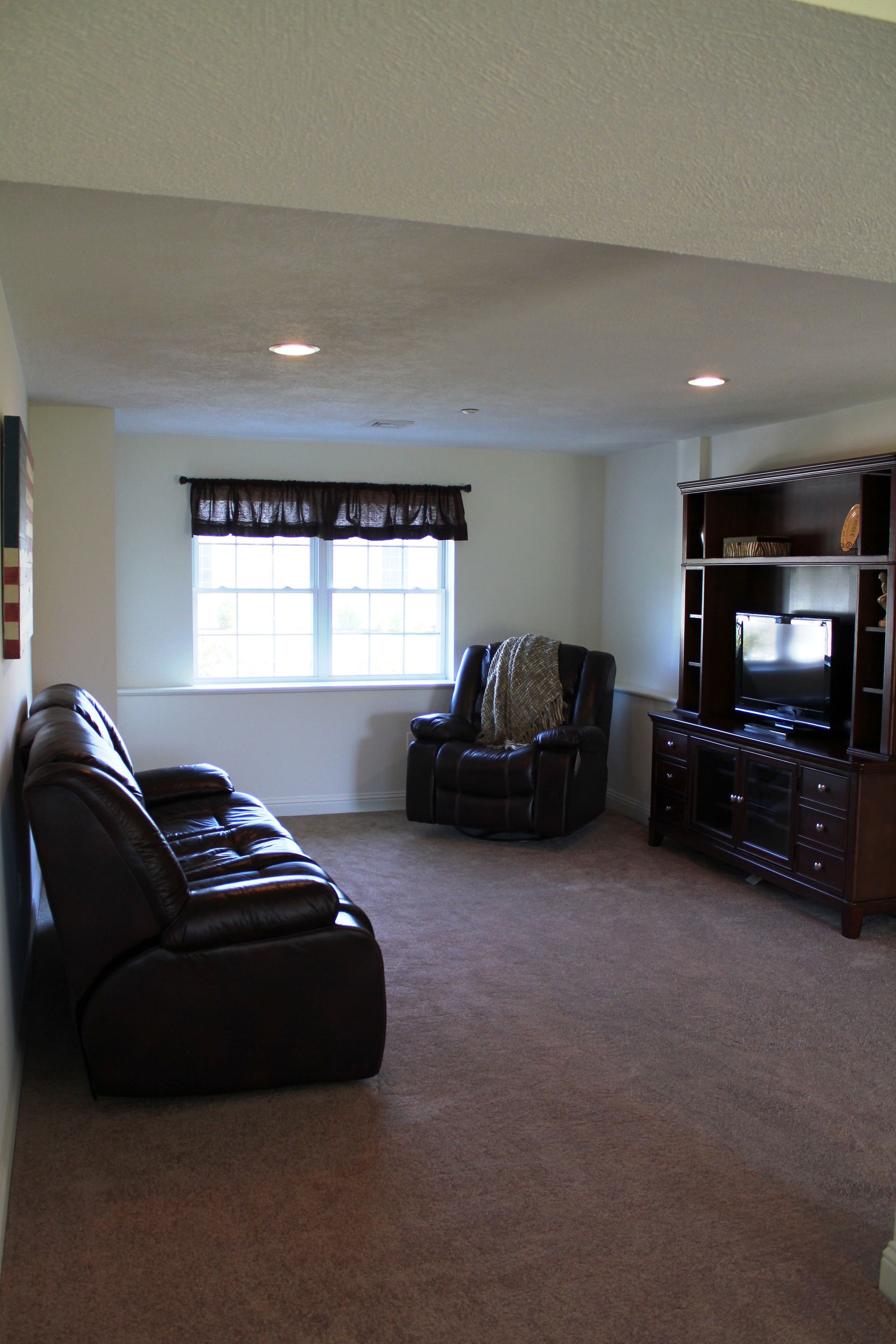 A living room with a couch a chair and a television