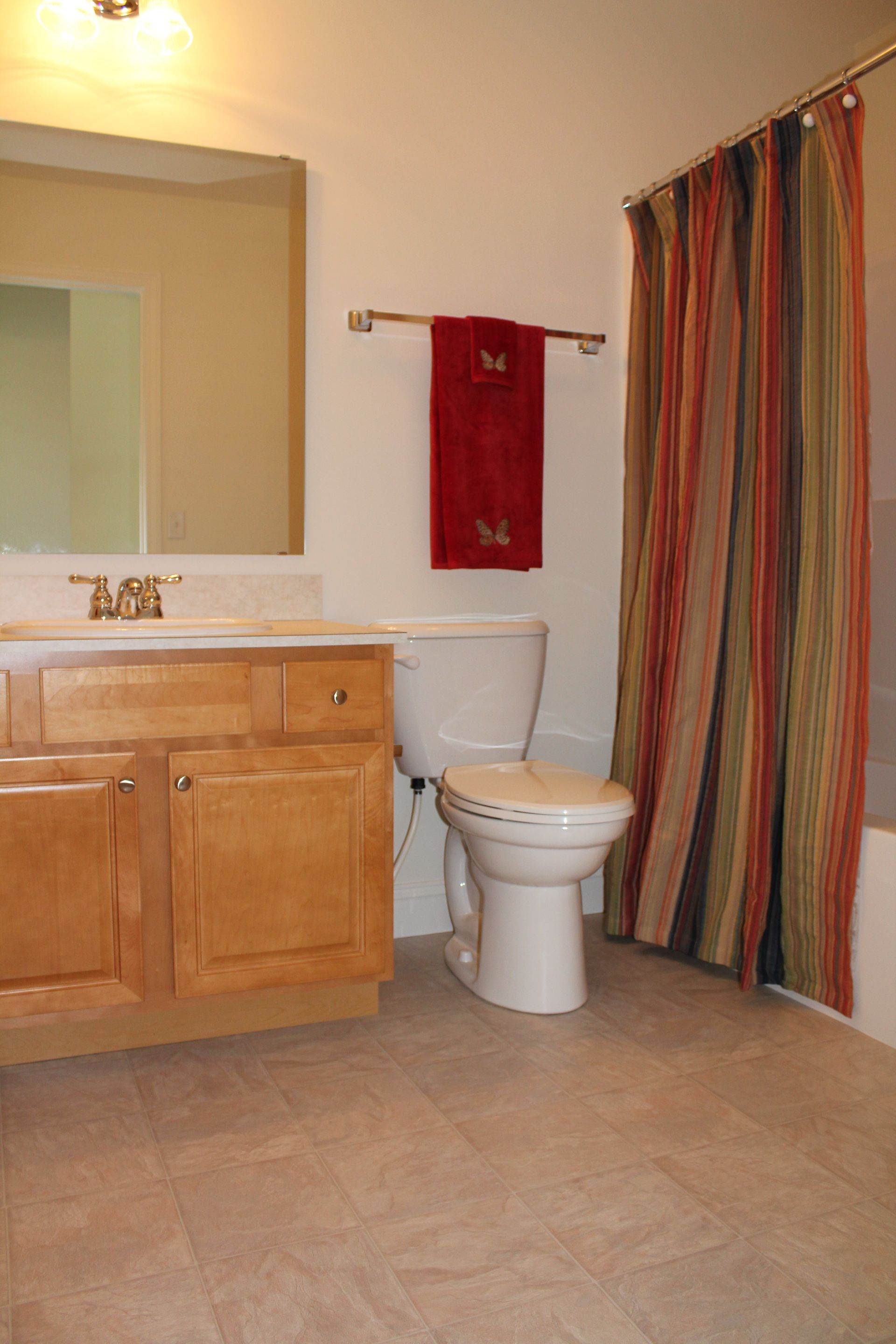 A bathroom with a toilet a sink and a mirror