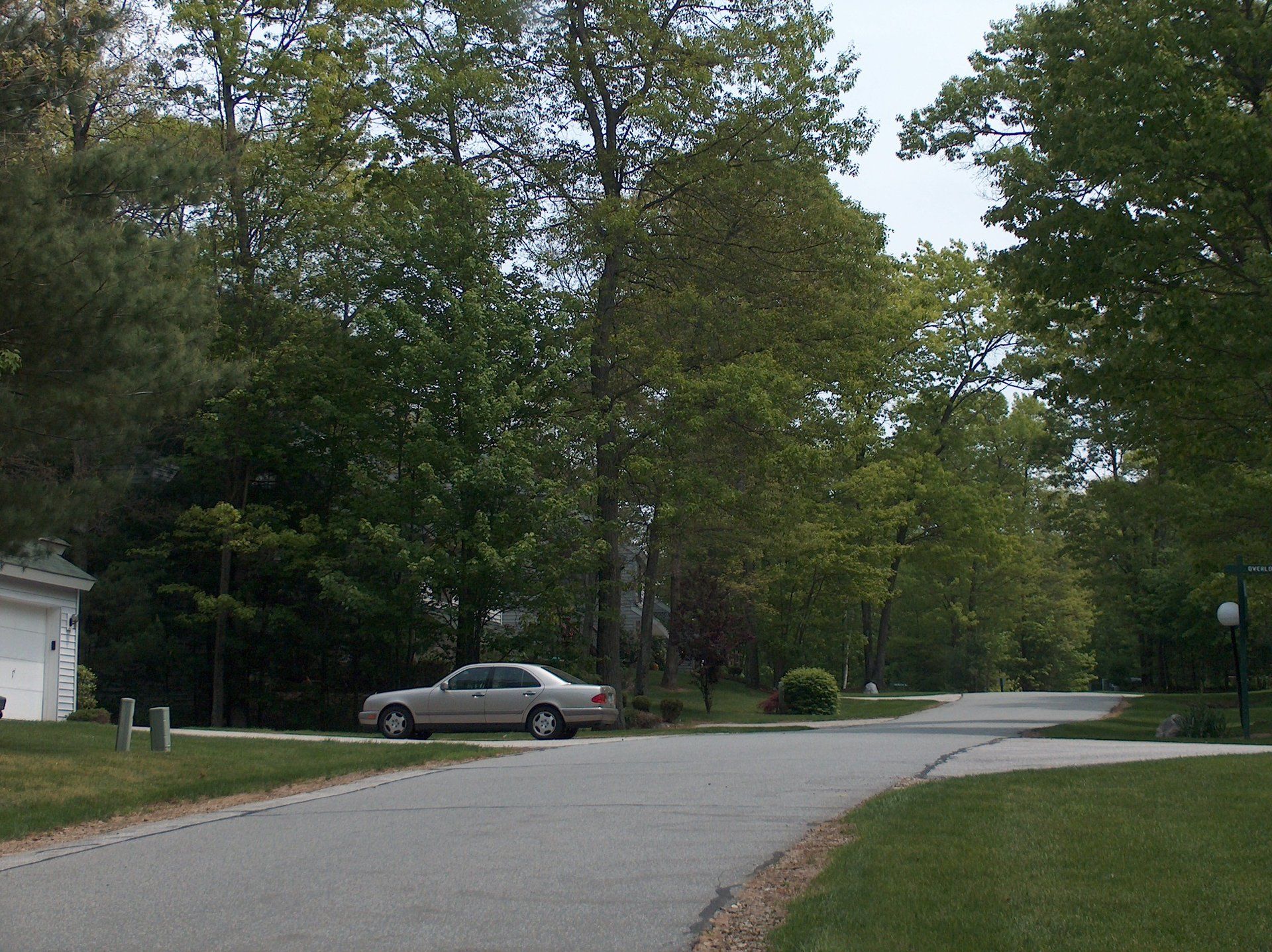 A white car is parked on the side of the road