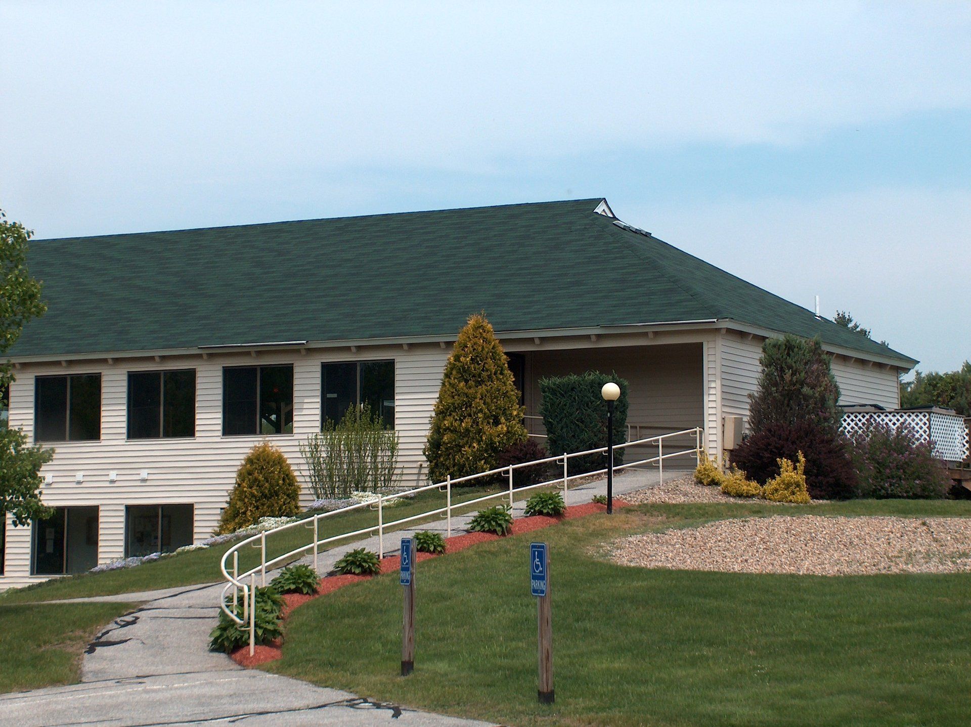 A large white house with a green roof