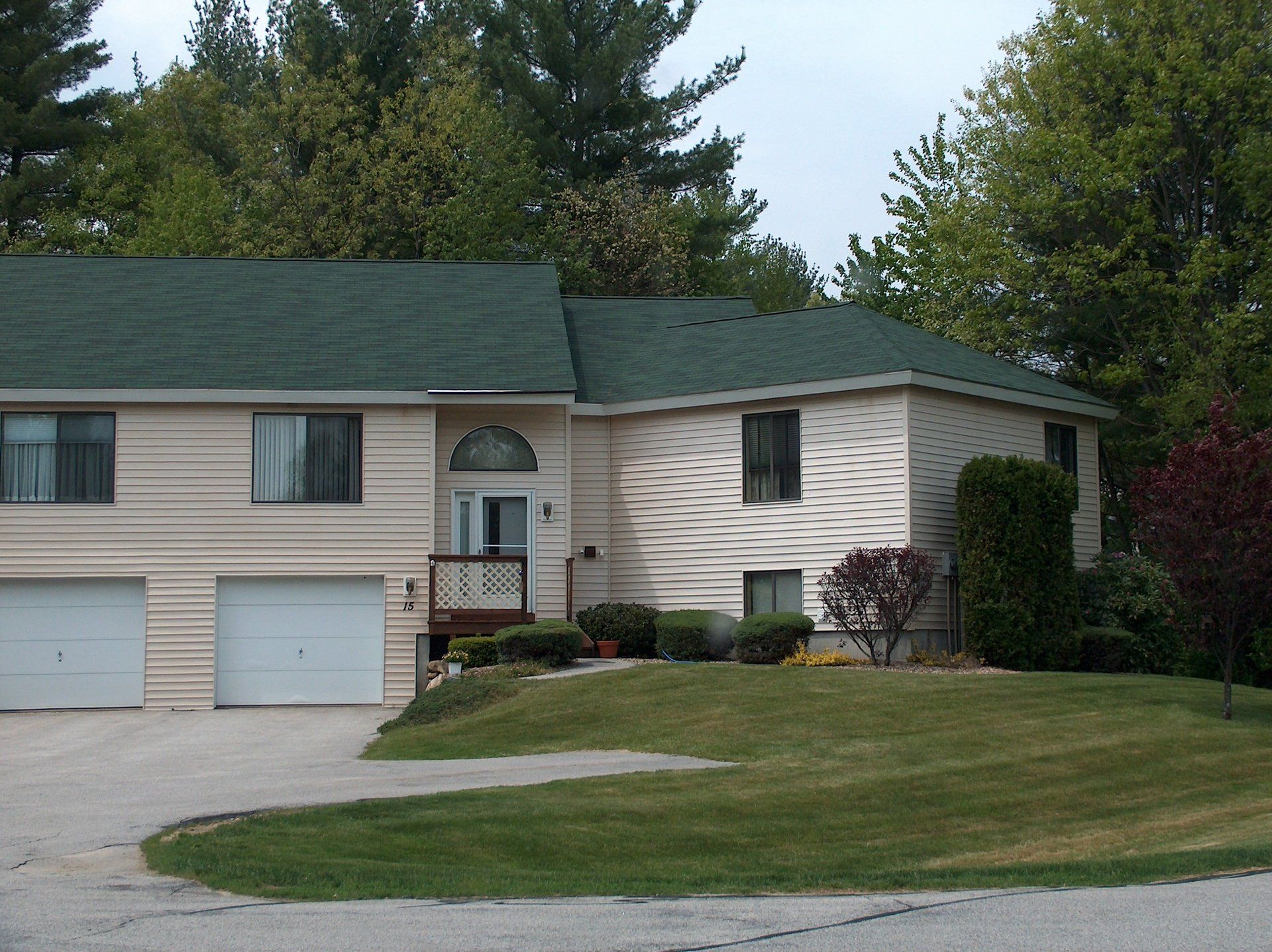 A house with a green roof and white garage doors