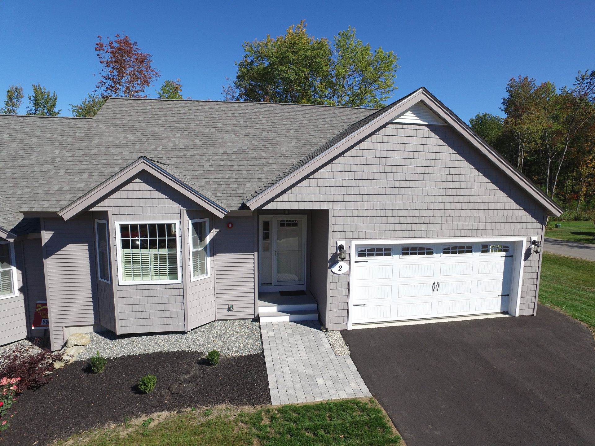 An aerial view of a house with a large garage