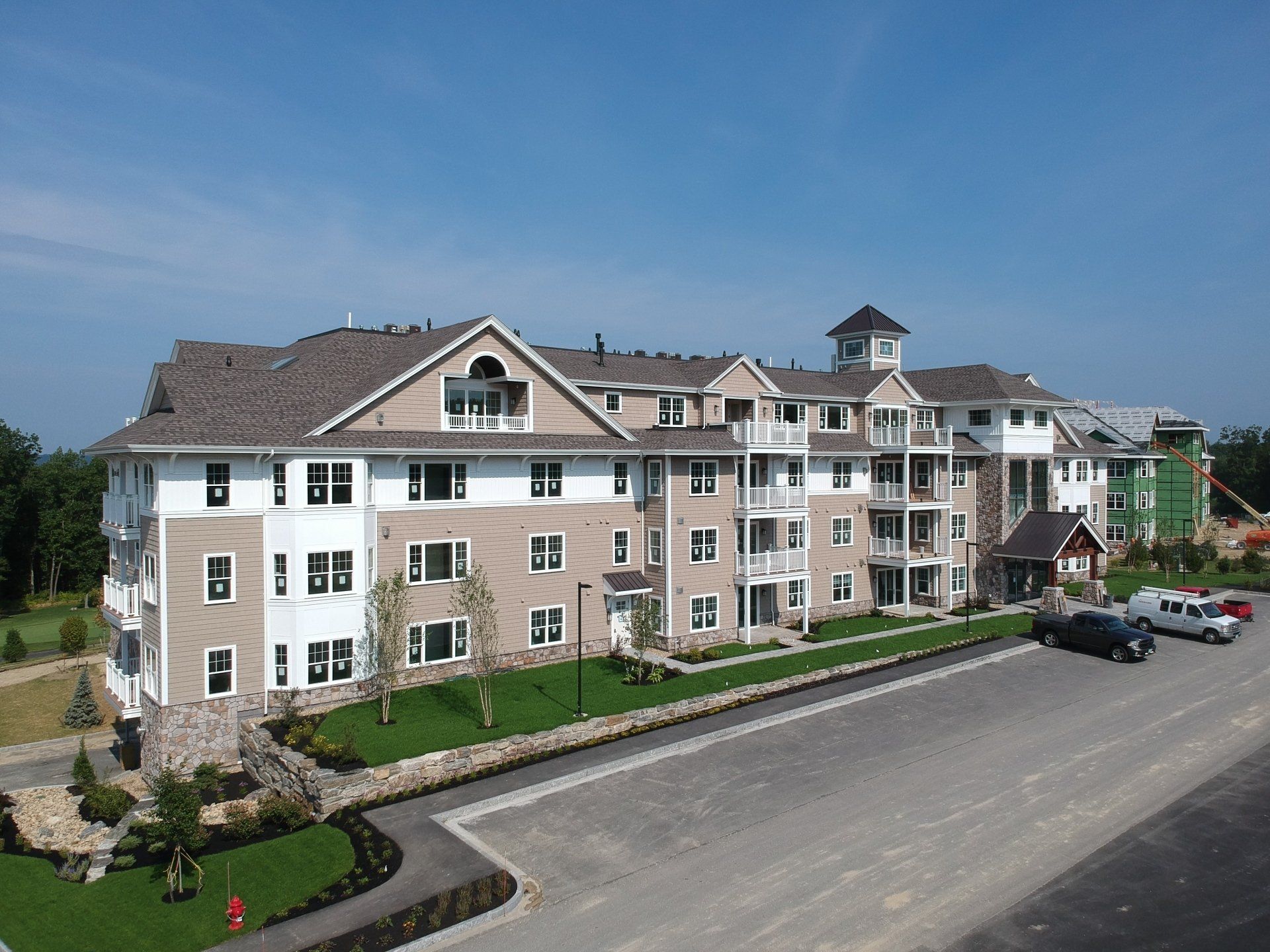 An aerial view of a large condo building with cars parked in front of it