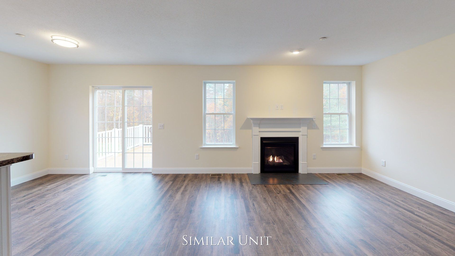 An empty living room with hardwood floors and a fireplace.