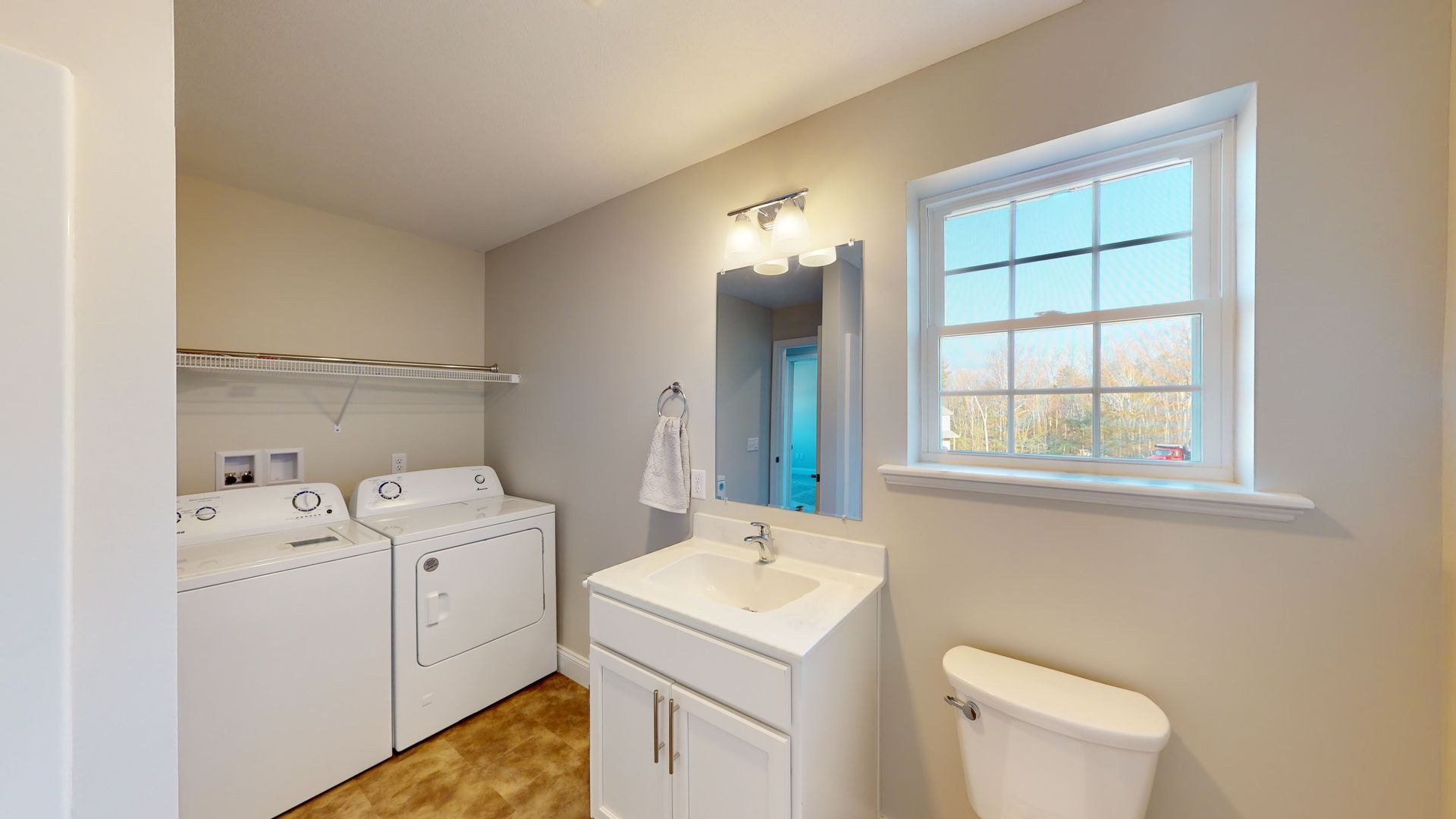 A laundry room with a washer and dryer , sink and toilet.
